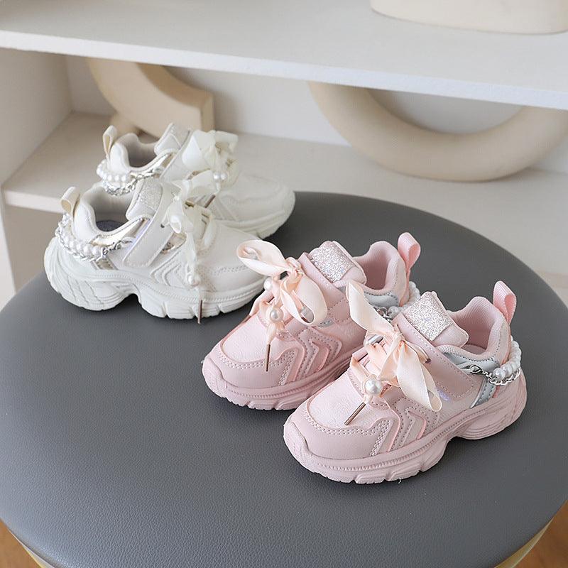 Little princess shoes decorated with lace straps and luxurious pearl necklace accents.