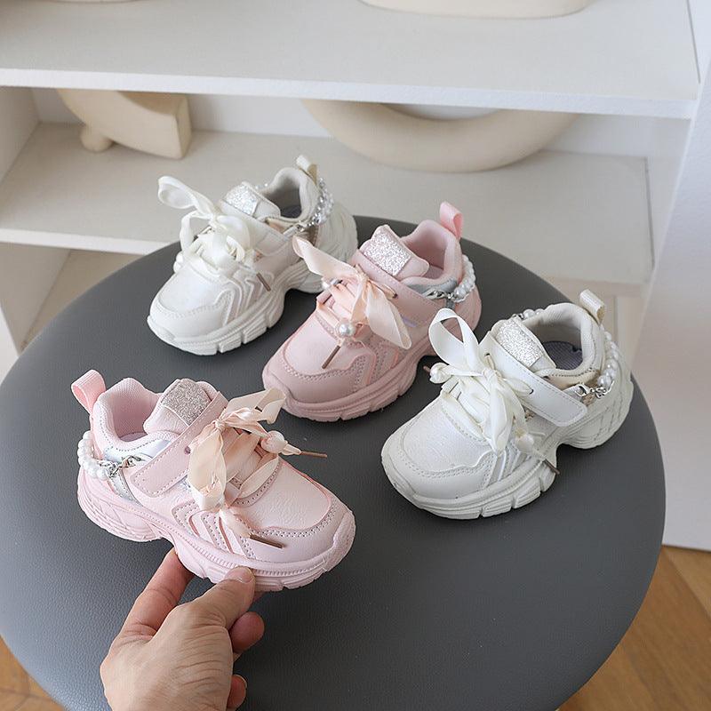 Little princess shoes decorated with lace straps and luxurious pearl necklace accents.