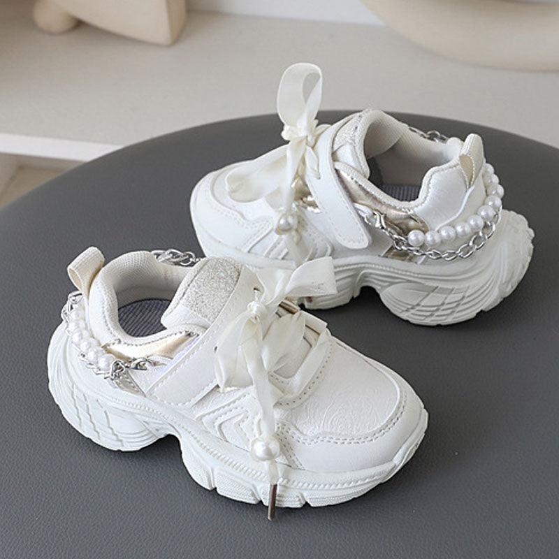 Little princess shoes decorated with lace straps and luxurious pearl necklace accents.