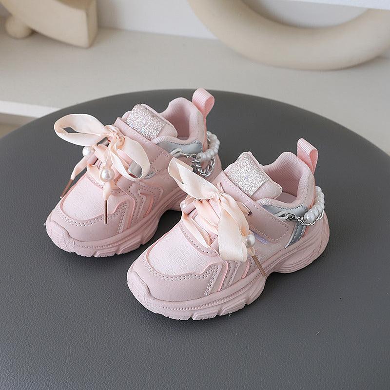 Little princess shoes decorated with lace straps and luxurious pearl necklace accents.